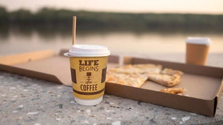 Custom branded takeaway coffee cup styled with pizza packaging by the waterfront