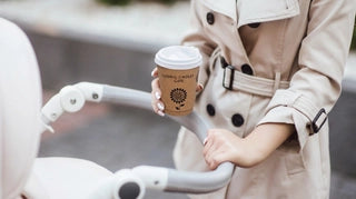 Custom kraft coffee cup in a lifestyle scene beside a stroller