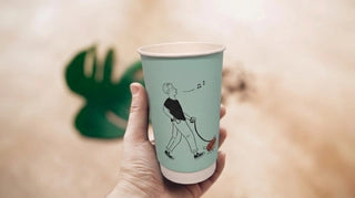 Custom printed paper cup with illustrated character artwork held in hand