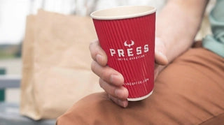 Red ripple branded paper cup shown in a close-up lifestyle photo